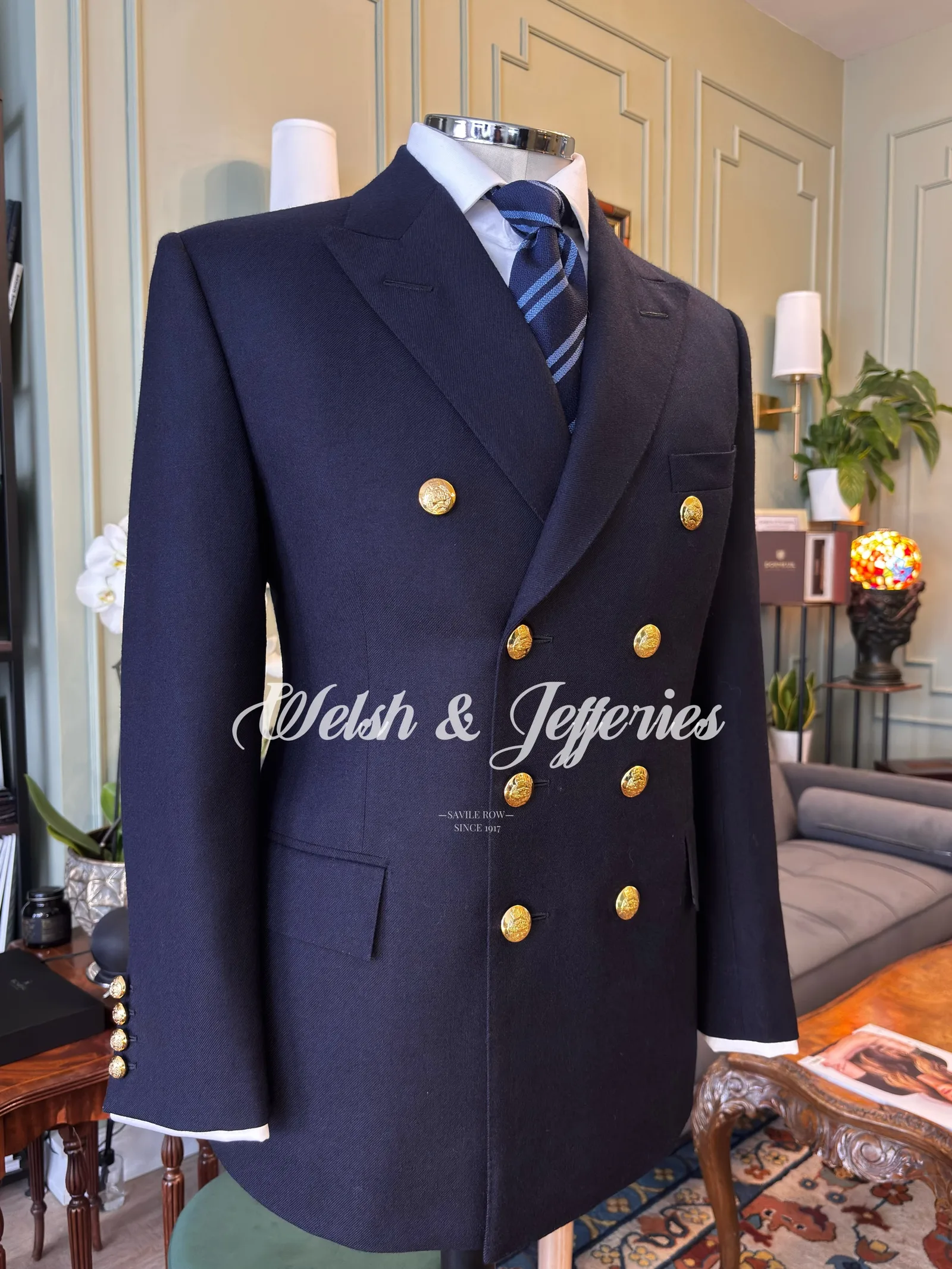 Midnight navy double-breasted blazer with broad peak lapels, gilt buttons and white cuff piping.