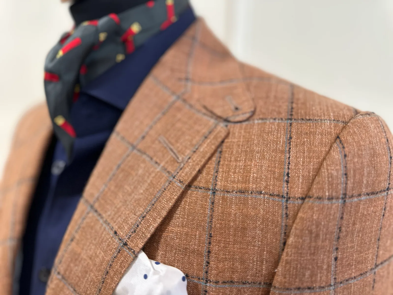 Close view of a rust windowpane sport coat, highlighting lapel and shoulder detail.