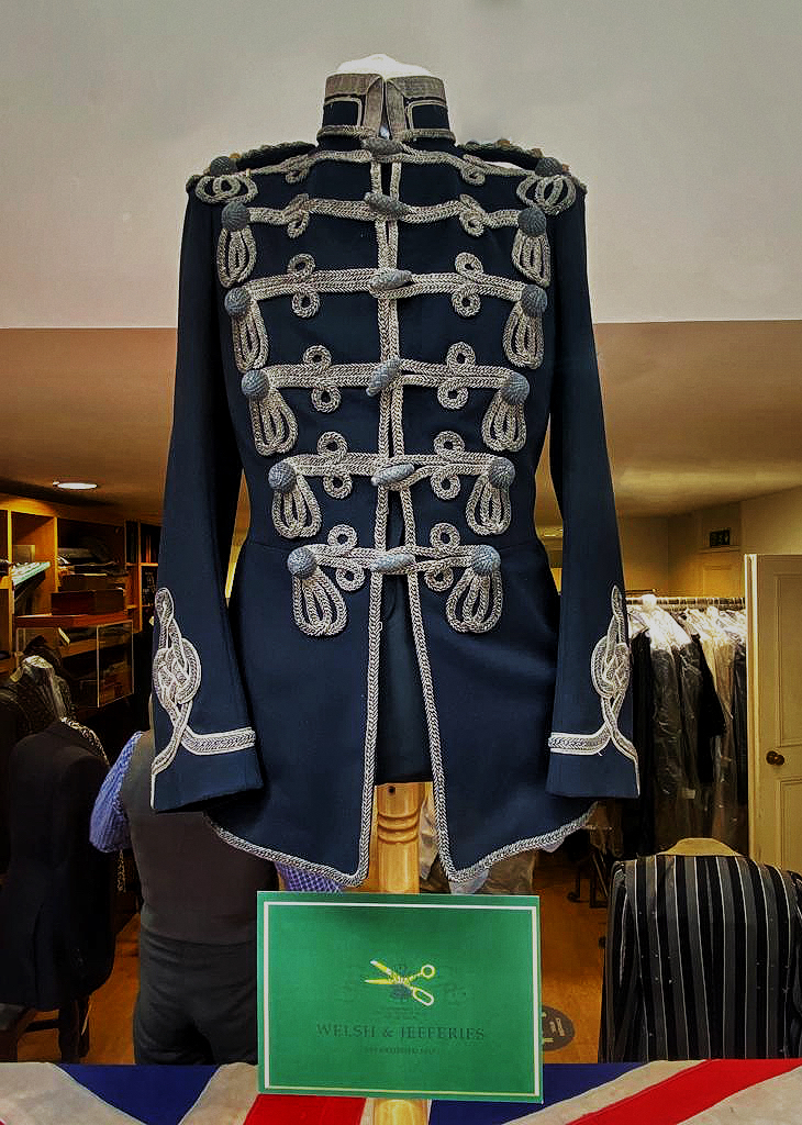 Midnight hussar tunic with six rows of silver frogging, olivets and trefoil cuffs.