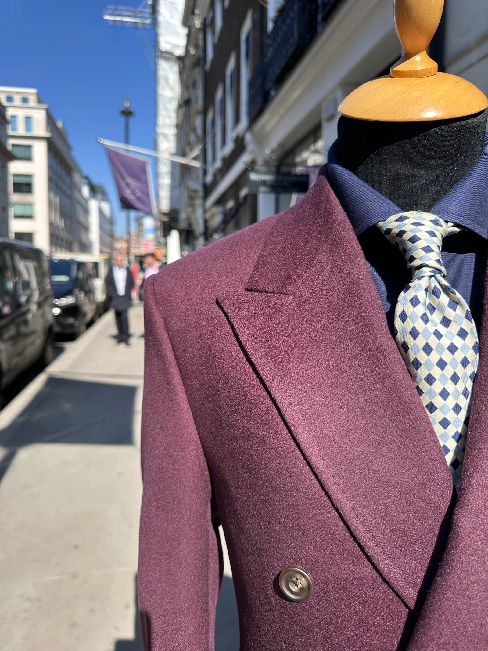 Close view of a deep mulberry double-breasted jacket, highlighting outdoor lapel detail.