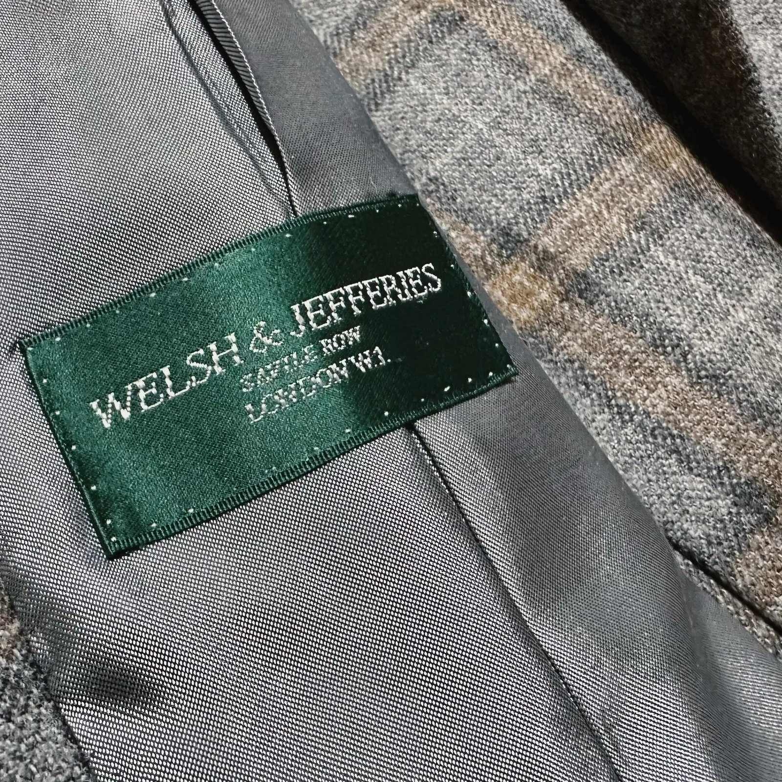 Interior lining detail inside soft grey windowpane ladies' jacket.