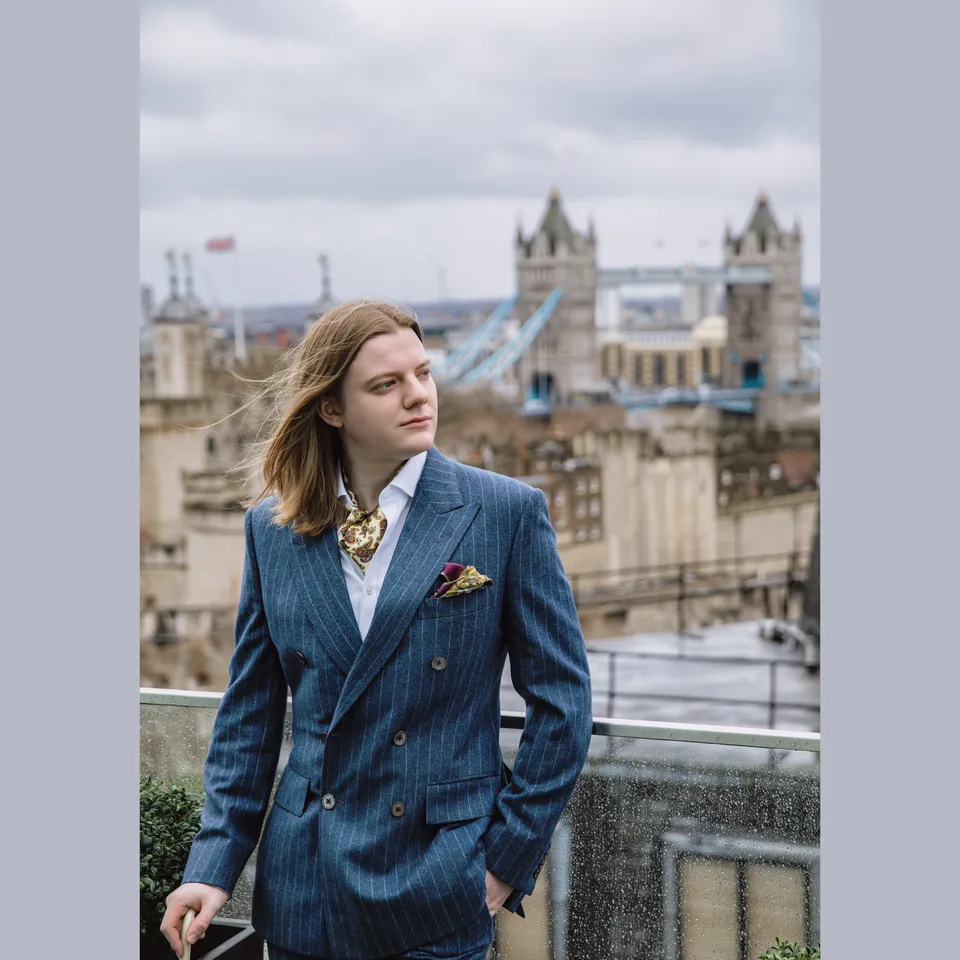 A gentleman overlooking Tower Bridge in a teal double-breasted suit.
