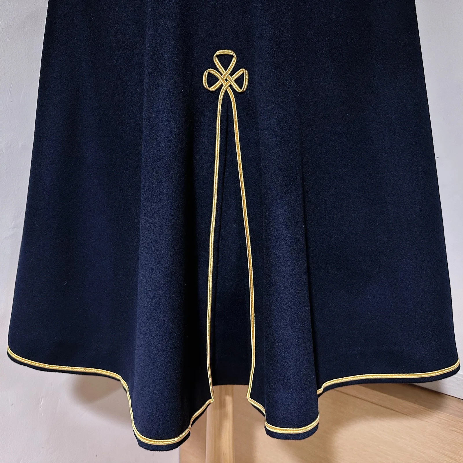 Back-vent detail on deep navy cavalry cape with gold piping.