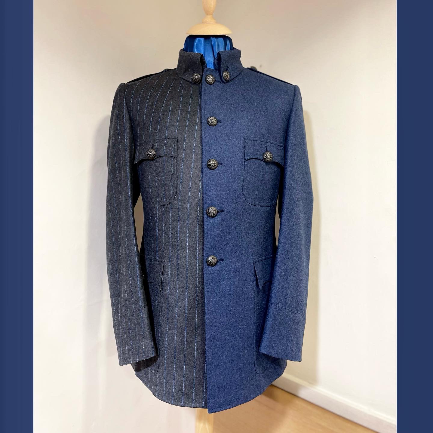 Military tunic divided between charcoal blue pinstripe and plain slate-blue wool.
