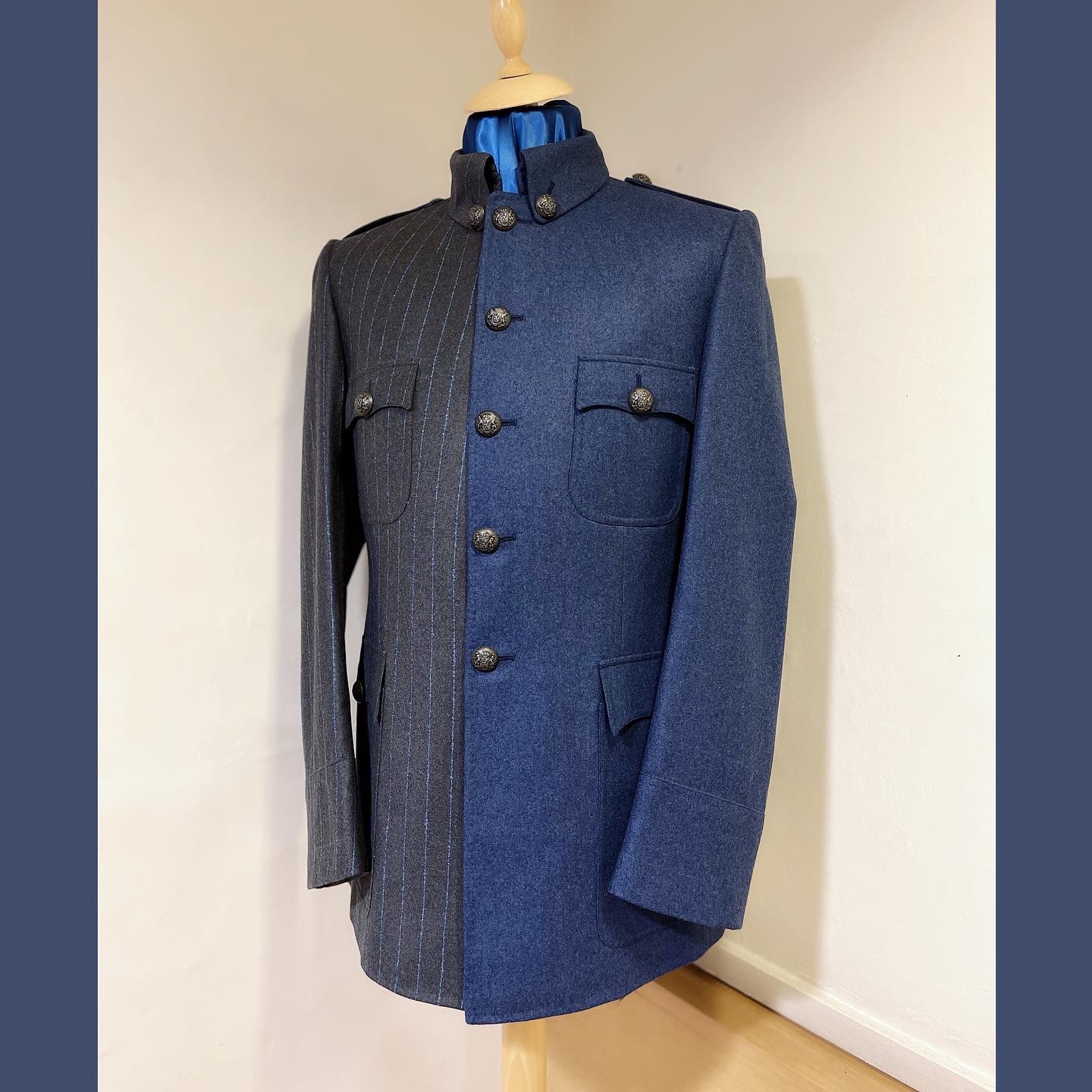 Military tunic divided between charcoal blue pinstripe and plain slate-blue wool.