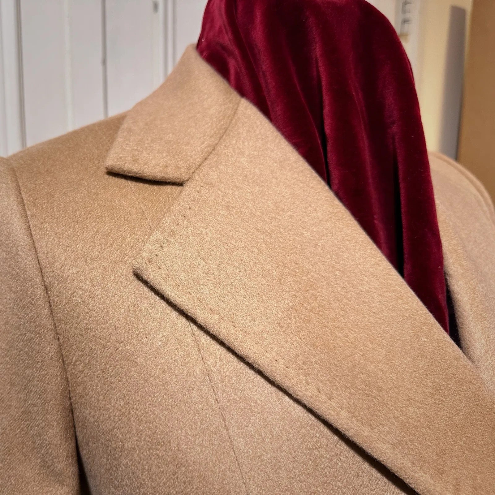 Lapel and chest detail on camel vicuña belted wrap coat.