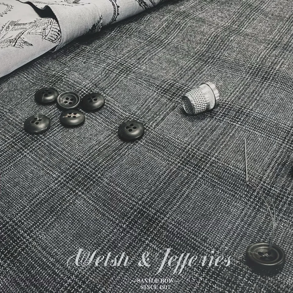 Close view of the cloth for charcoal Prince of Wales check cloth and tailoring components.