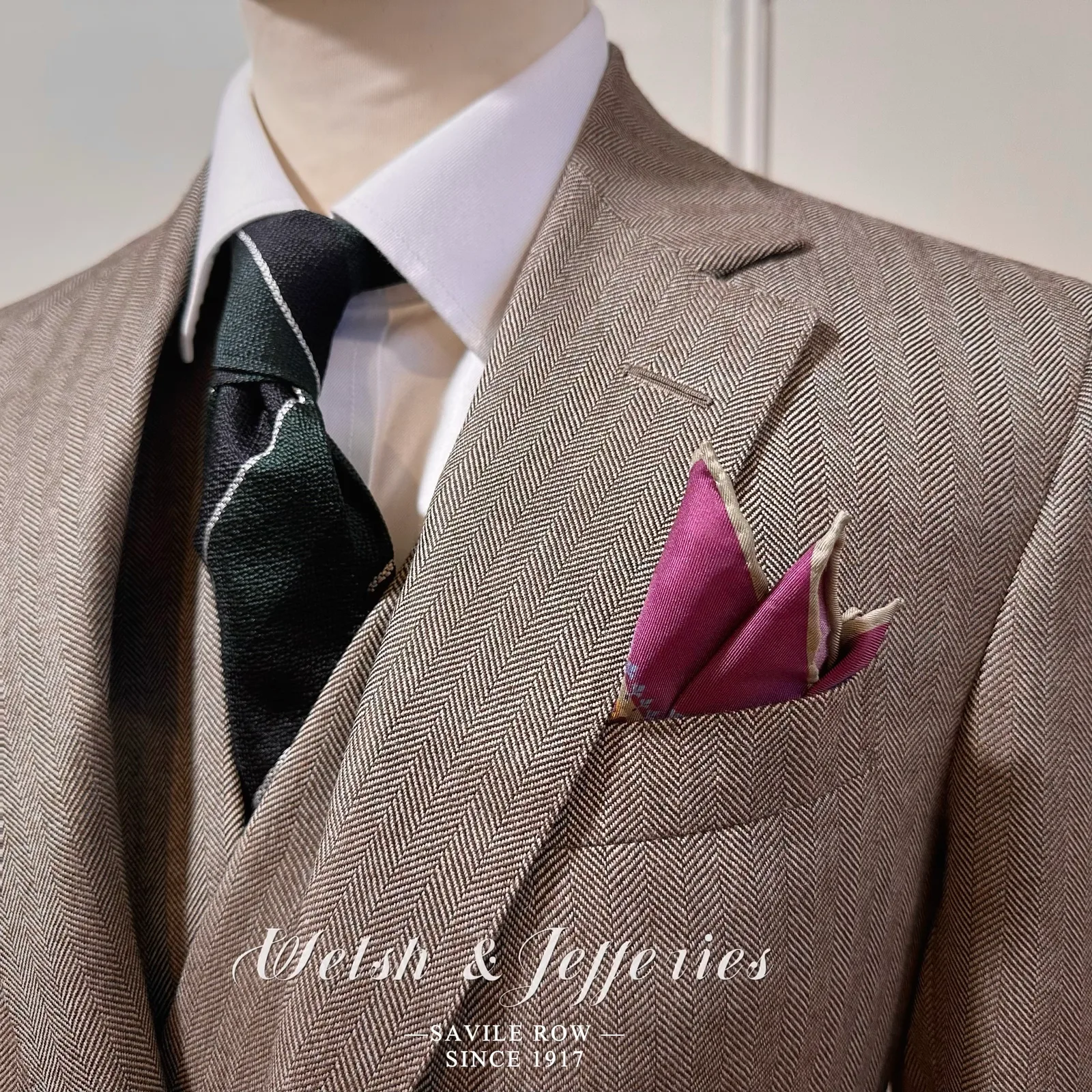 Close view of taupe herringbone, horn buttons, pocket finishing and map-print lining.