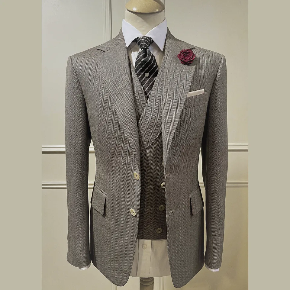 Taupe three-piece suit with a peak-lapel jacket and neatly fitted matching waistcoat.