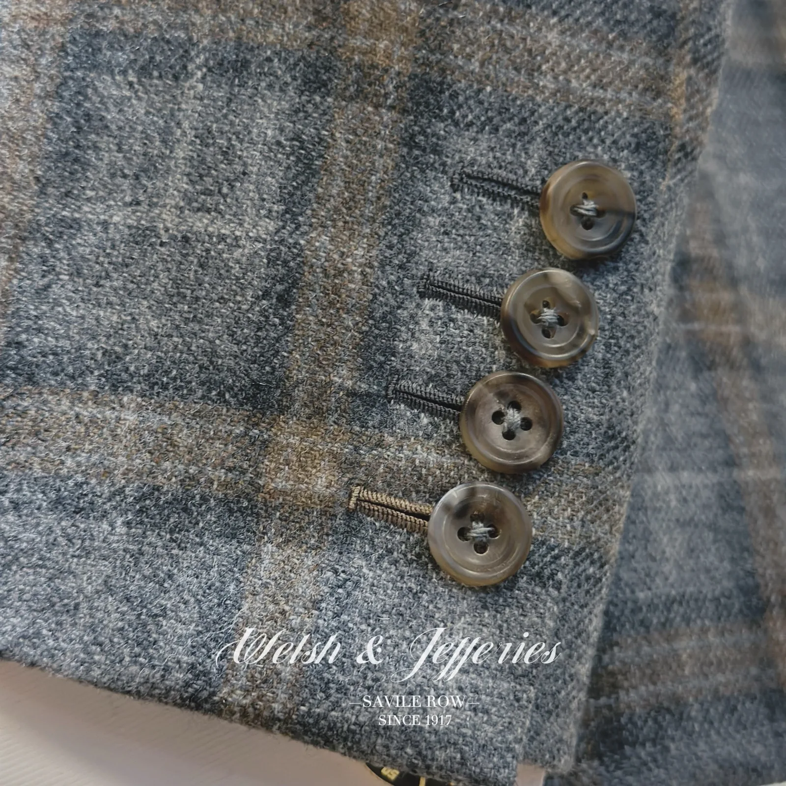 Cuff and sleeve detail on soft grey windowpane ladies' jacket.