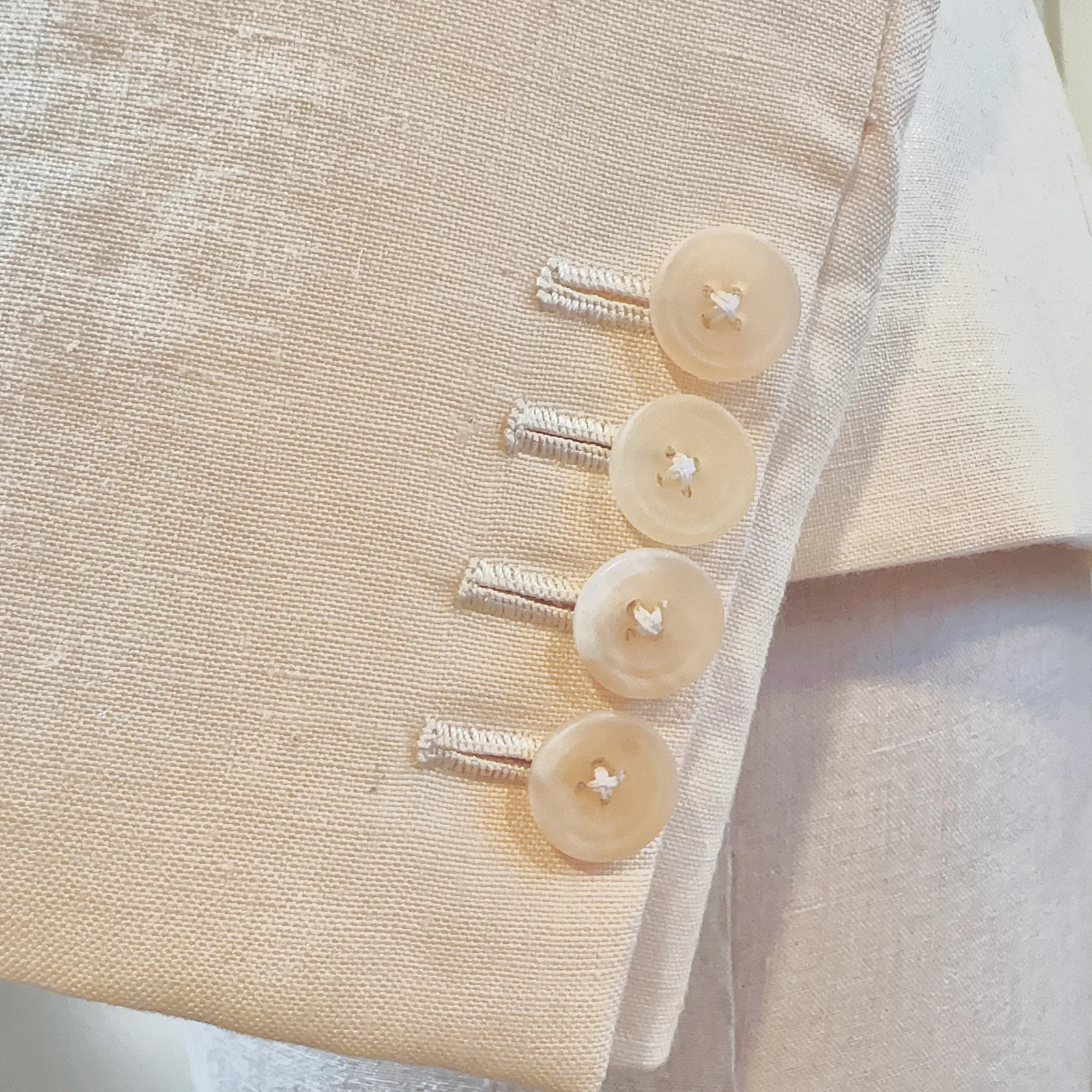 Cuff and sleeve detail on ivory basketweave ladies' jacket.