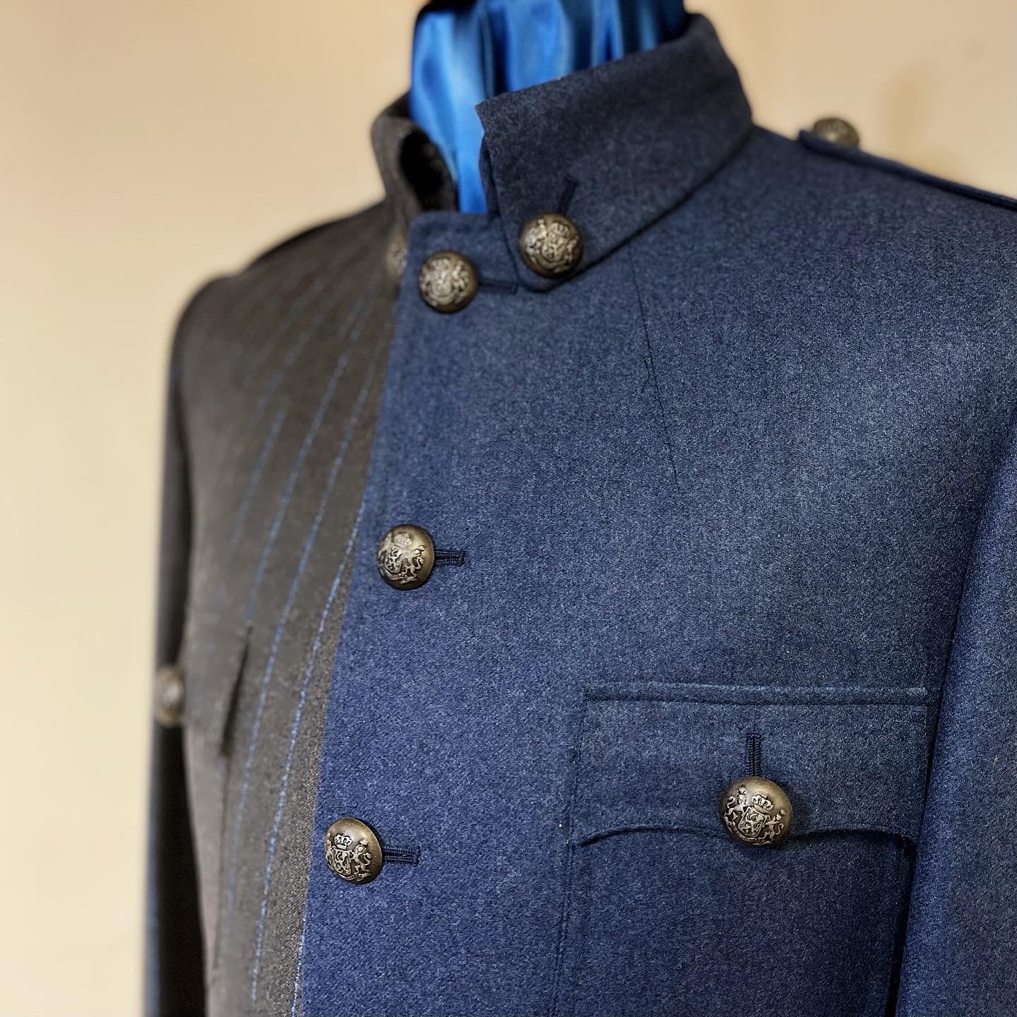 Slate-blue half of the military tunic with stand collar, breast pocket and armorial buttons.