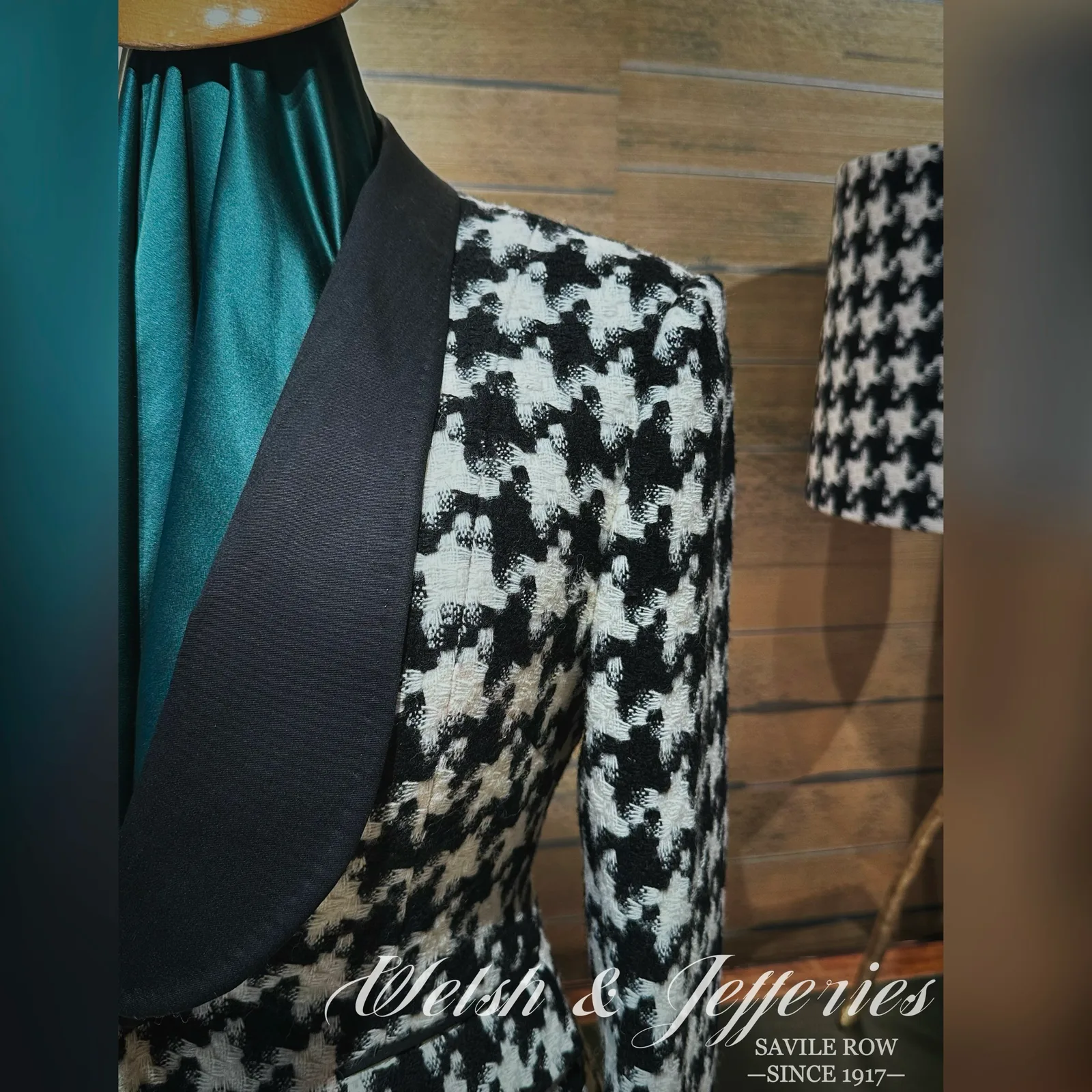 Lapel and chest detail on black-and-ivory houndstooth ladies' jacket with a black shawl collar.